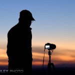 Photographer shooting photos of sunest over Anchorage and Mt. McKninley from Glen Alps