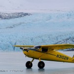 Cessna 120 parked on frozen Lake George in front of Colony Glacier, Alaska