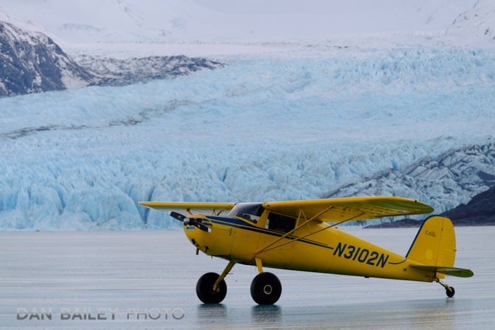 Cessna 120 parked on frozen Lake George in front of Colony Glacier, Alaska